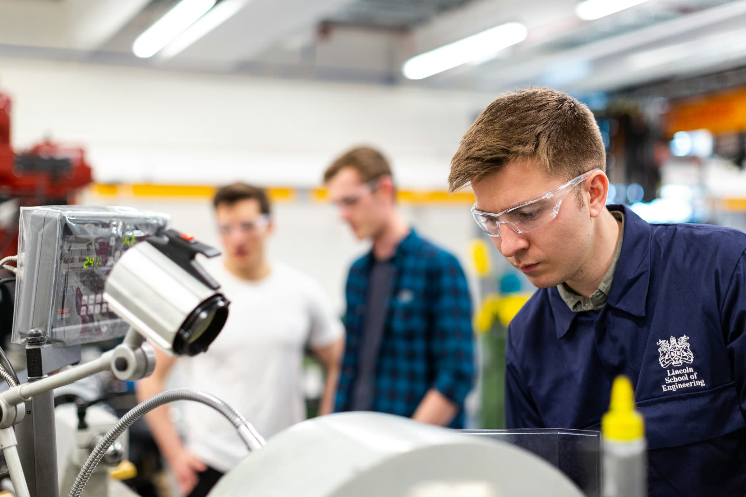 Engineers gathered around a machine in a workshop
